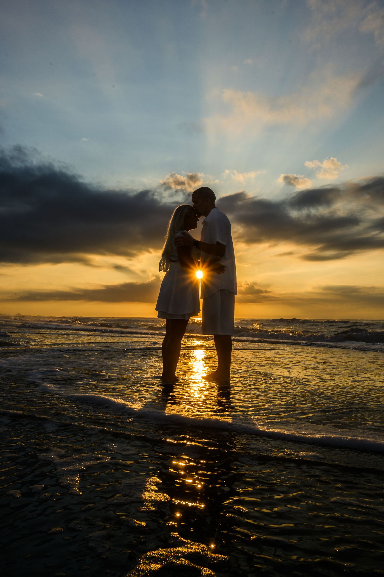 Couple silhouetted together at sunset on the beach