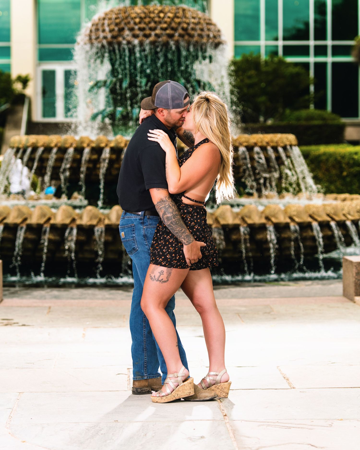 Couple sharing a portrait beside a city fountain