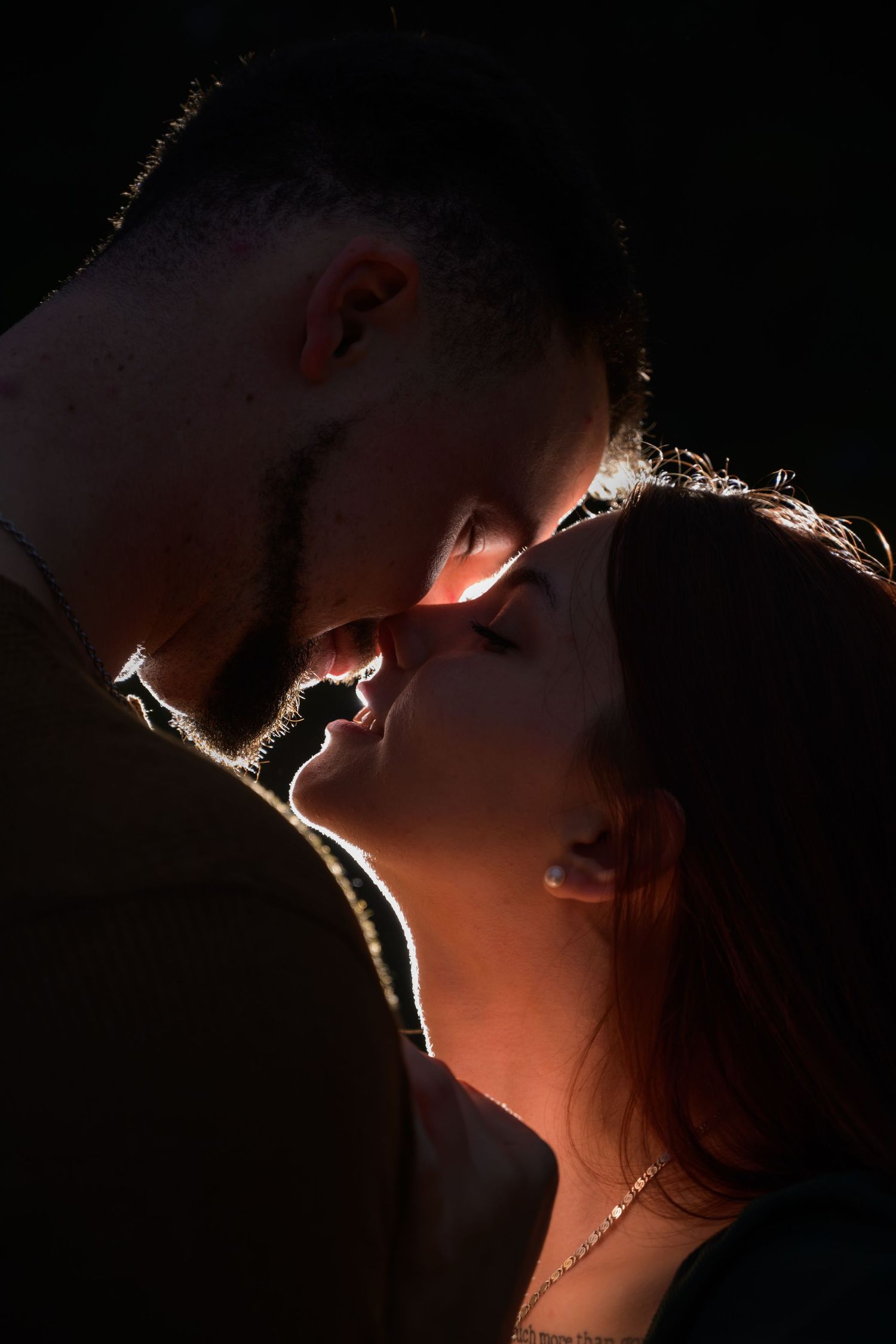 Couple sharing a dramatic backlit close-up